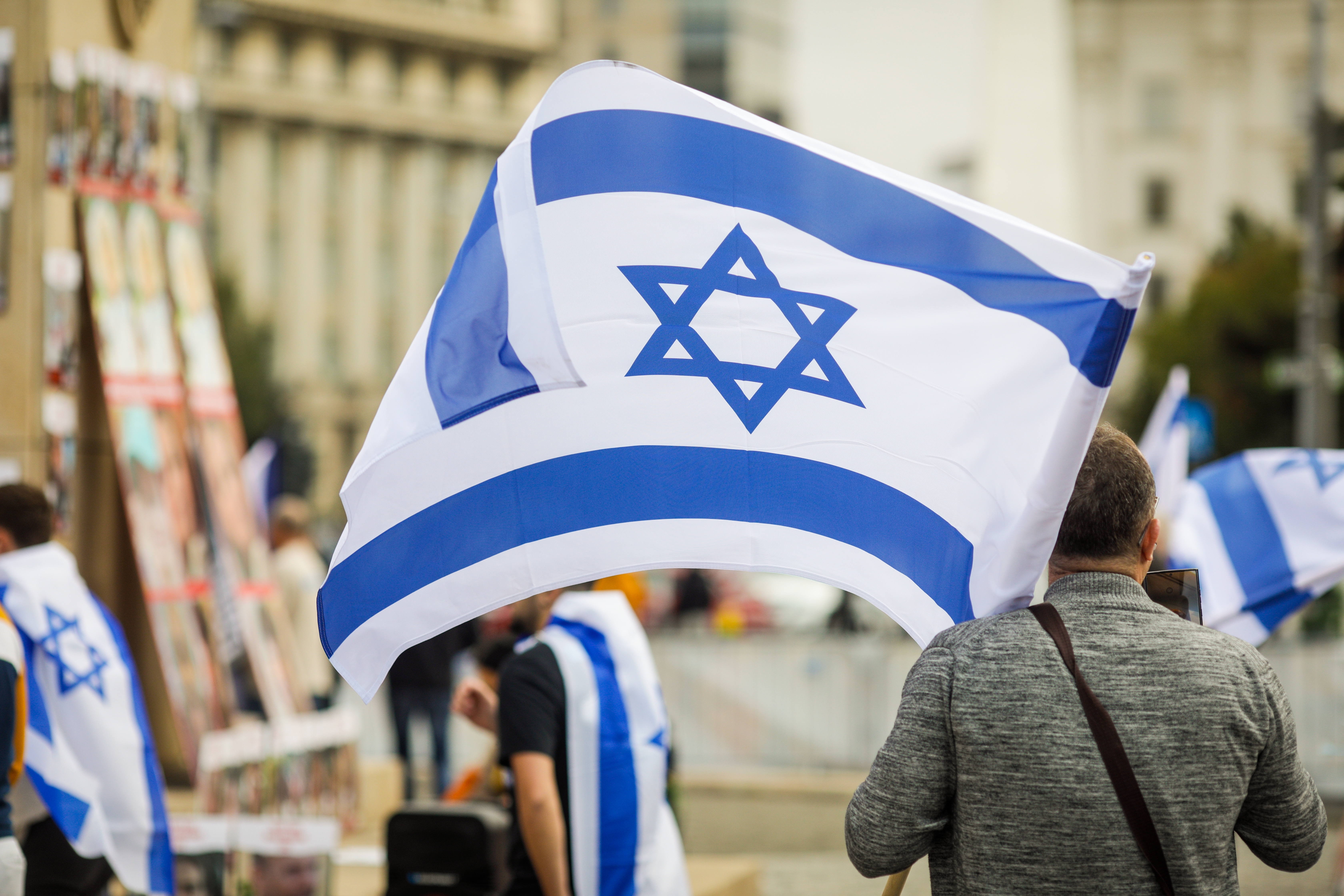 Person holding an Israeli flag at a public demonstration