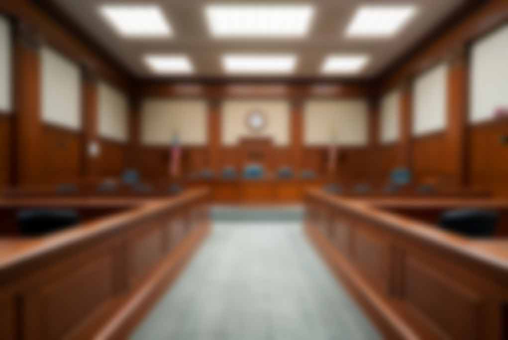 Empty courtroom with wooden benches and judge's bench