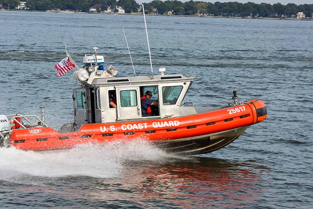 Coast Guard patrol boat speeding across a bay