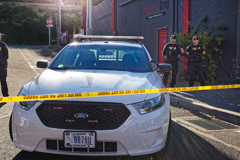 Police car behind yellow caution tape on a city street