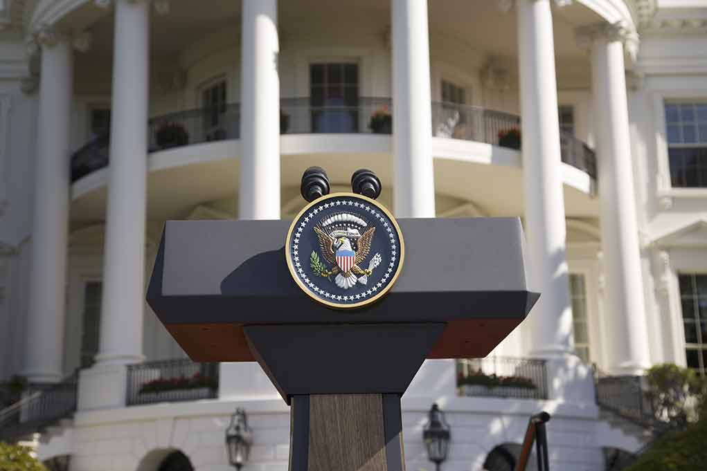 Presidential podium with seal in front of white-columned building